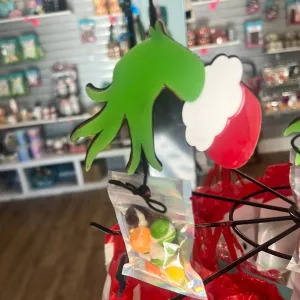 Acrylic, grinch hand, ornament, attached to a bag of freeze dried treats